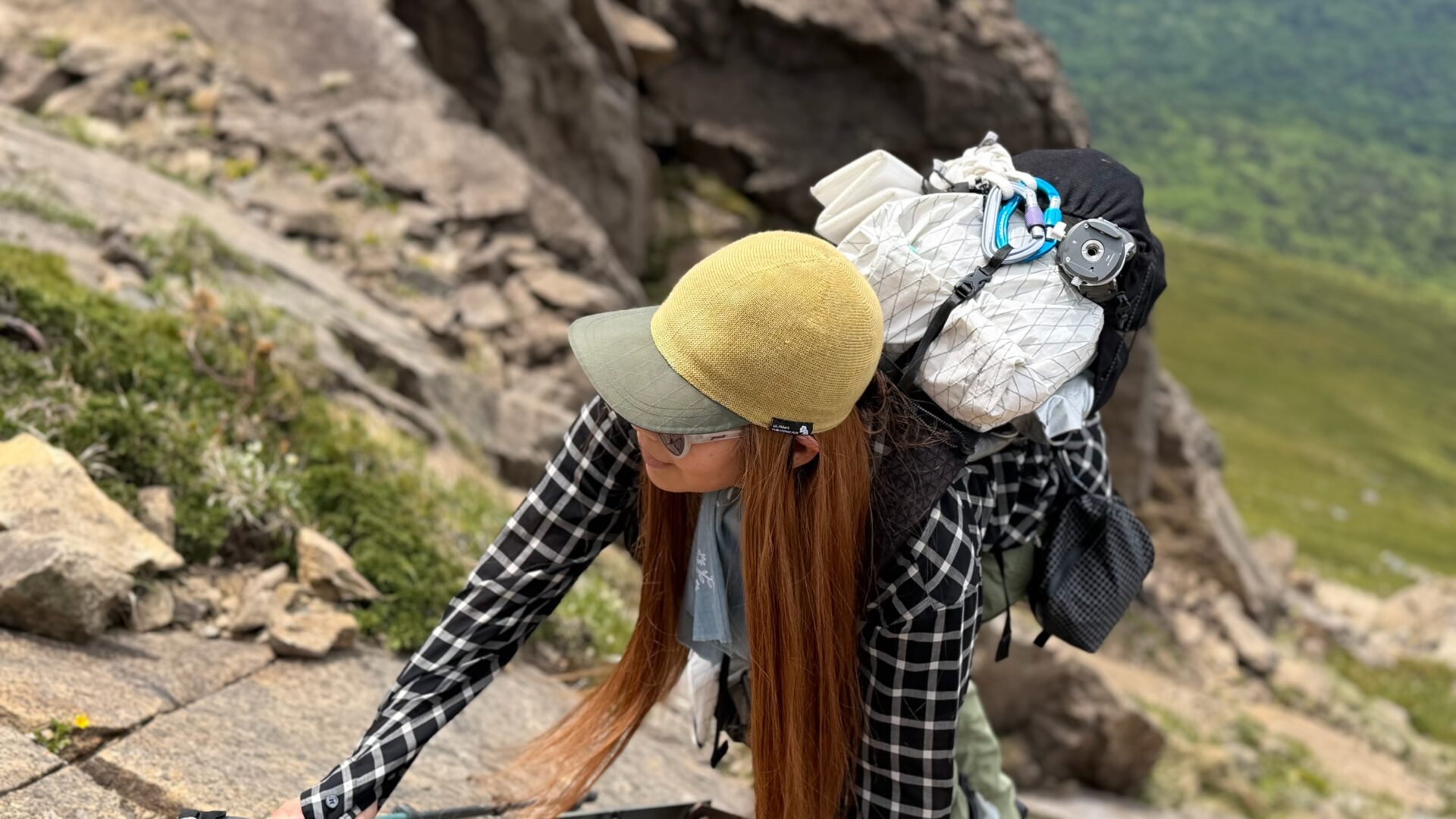 U.L. Merino X Capを被って岩場の登山道を登る様子